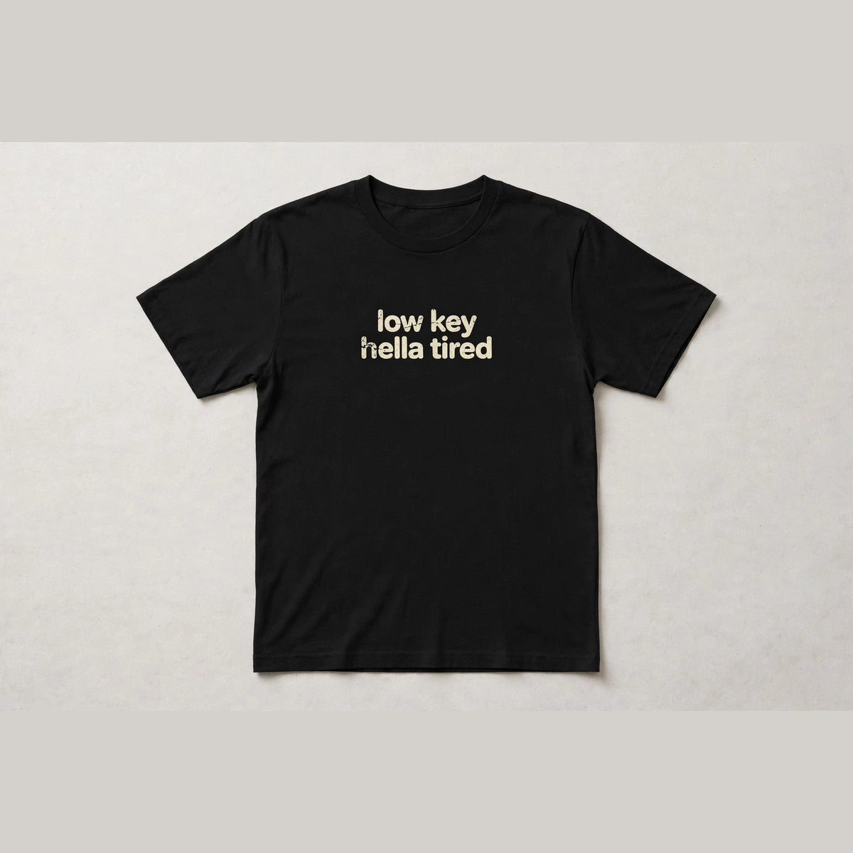 Low Key Hella Tired funny slang t-shirt in Black - distressed cream lowercase text, Bella Canvas tee, flat lay front view, funny tired humor shirt