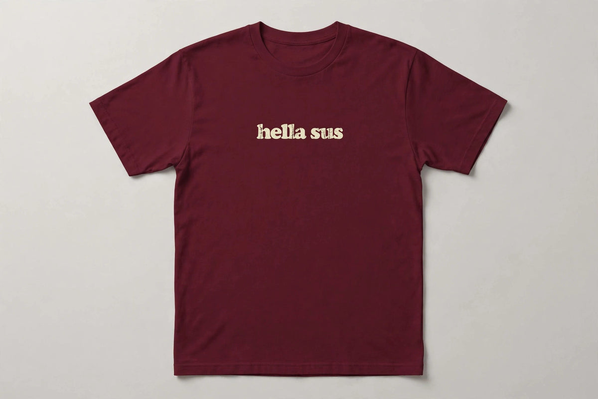 Hella Sus funny slang t-shirt in Maroon - distressed cream lowercase text, Bella Canvas tee, flat lay front view, funny suspicious humor shirt
