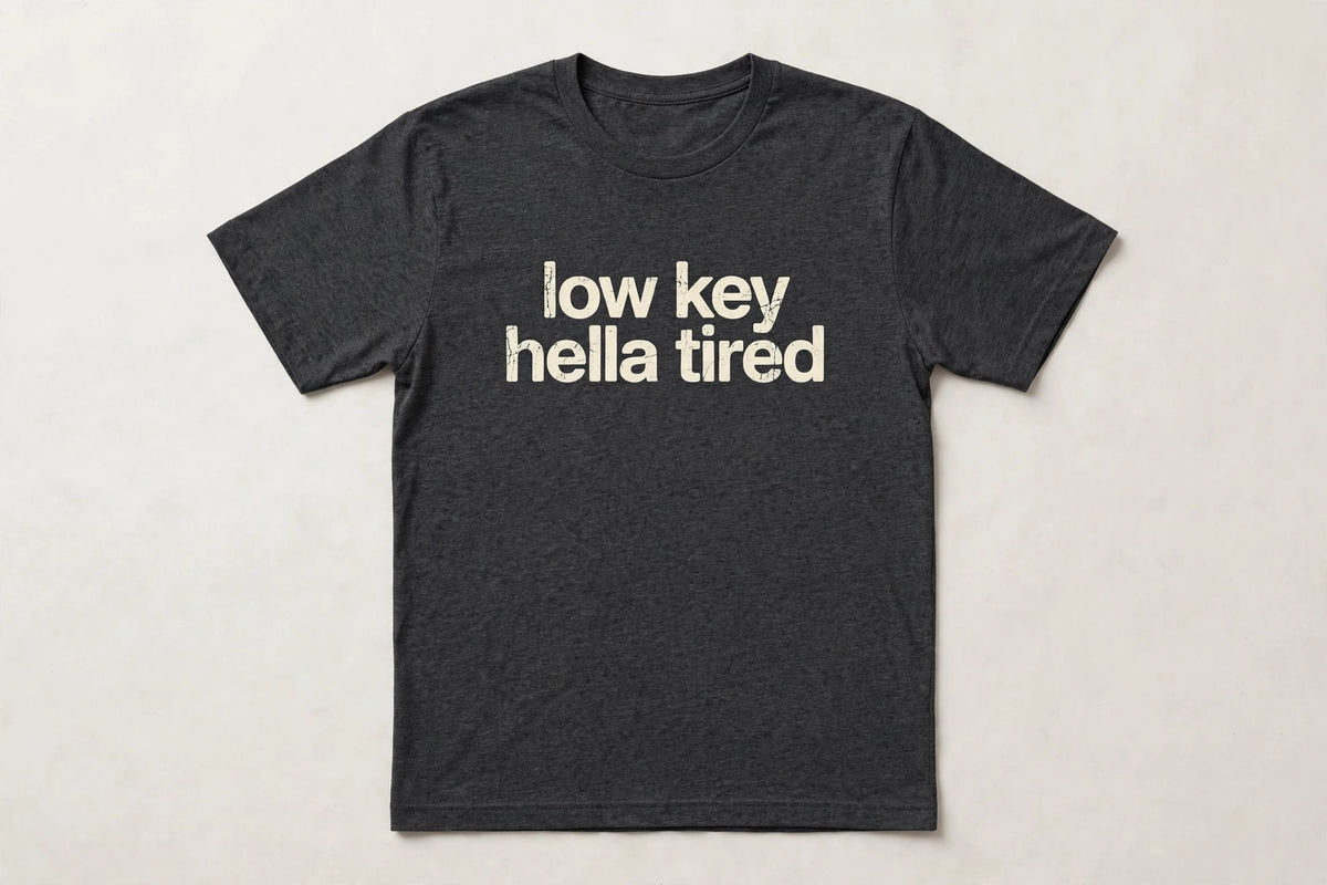 Low Key Hella Tired funny slang t-shirt in Dark Grey Heather - distressed cream lowercase text, Bella Canvas tee, flat lay front view, funny tired humor shirt