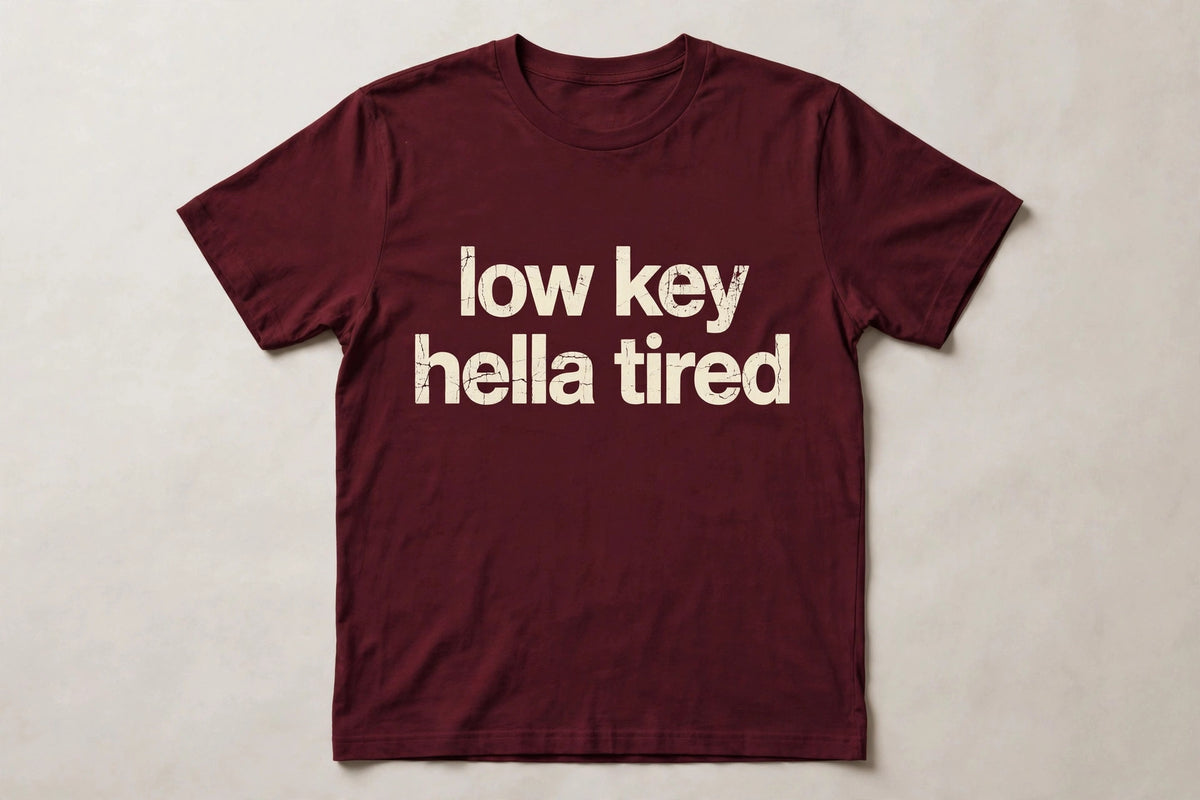 Low Key Hella Tired funny slang t-shirt in Maroon - distressed cream lowercase text, Bella Canvas tee, flat lay front view, funny tired humor shirt