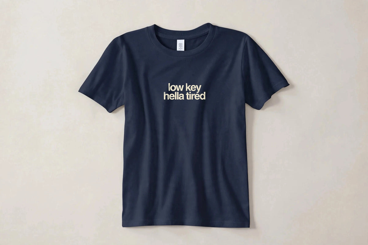 Low Key Hella Tired funny slang t-shirt in Navy - distressed cream lowercase text, Bella Canvas tee, flat lay front view, funny tired humor shirt