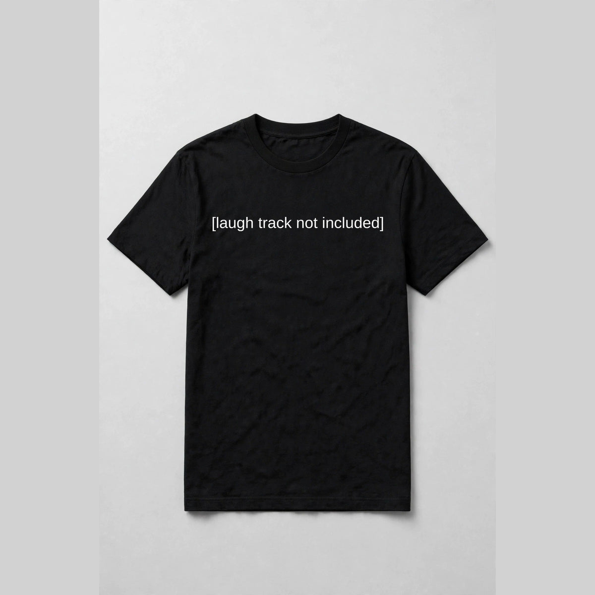 Black t-shirt with white subtitle text [laugh track not included] across the chest like a movie caption